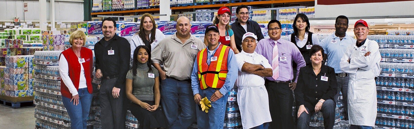 Costco employees from a variety of roles pose in warehouse
