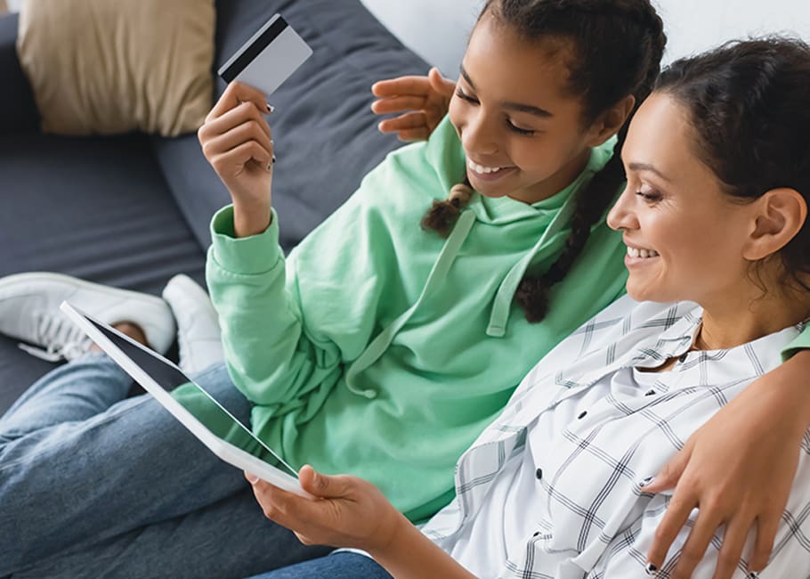 a child with a credit card sitting with a woman