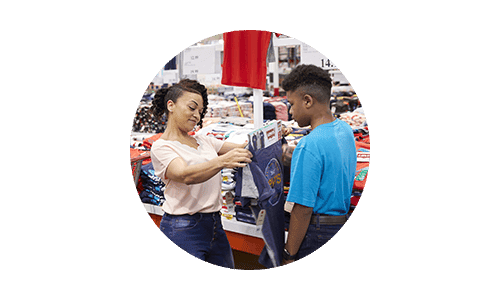 Costco members mom and son shopping for back to school clothing at Costco warehouse