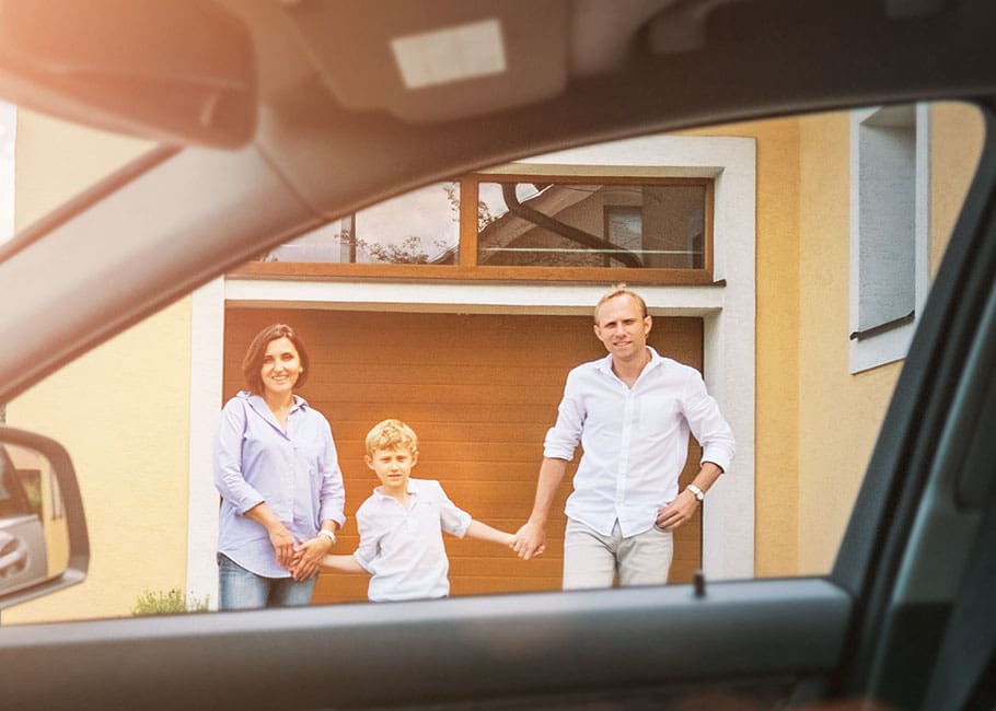 Family holding hands outside of a car