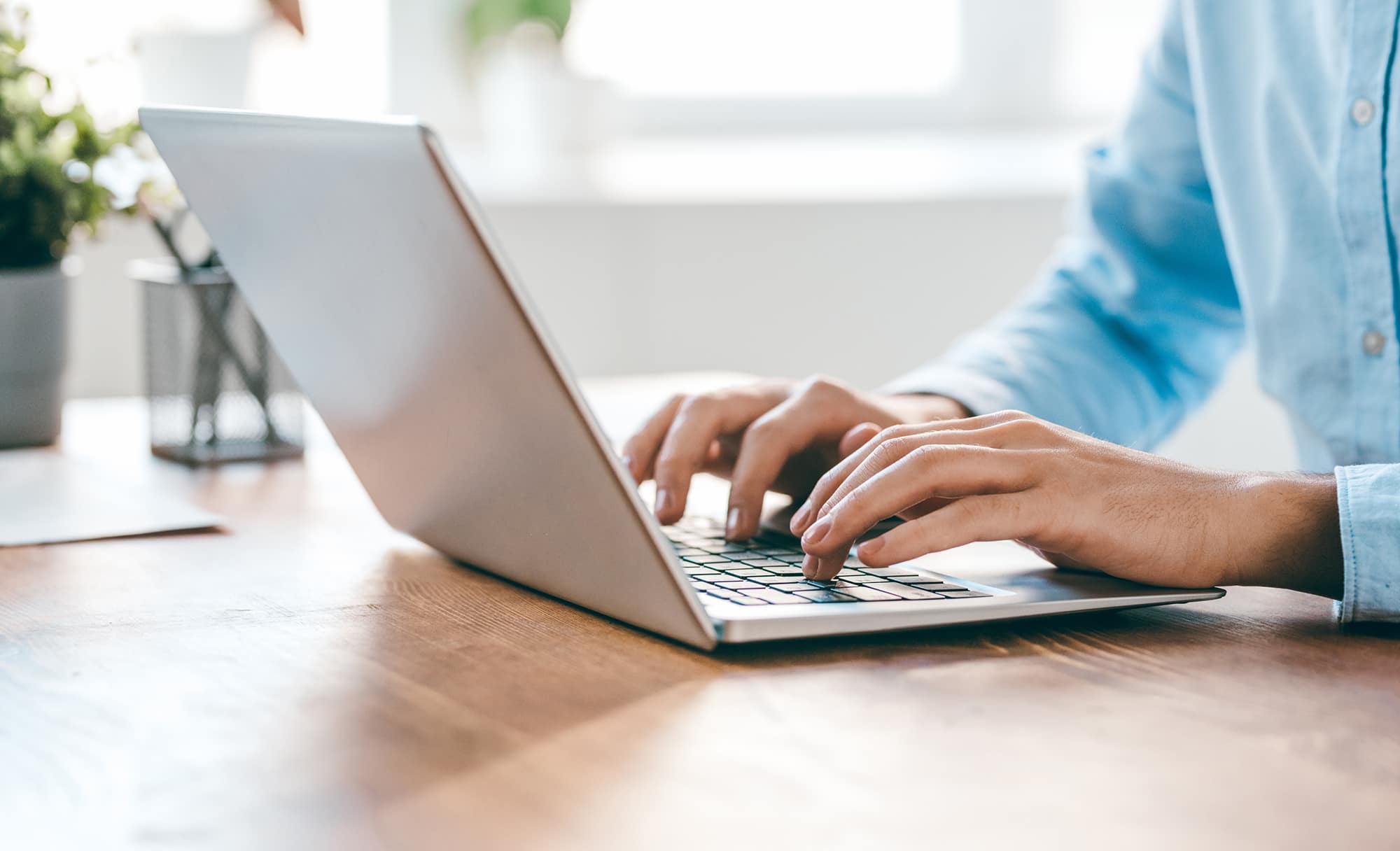 man typing on laptop computer