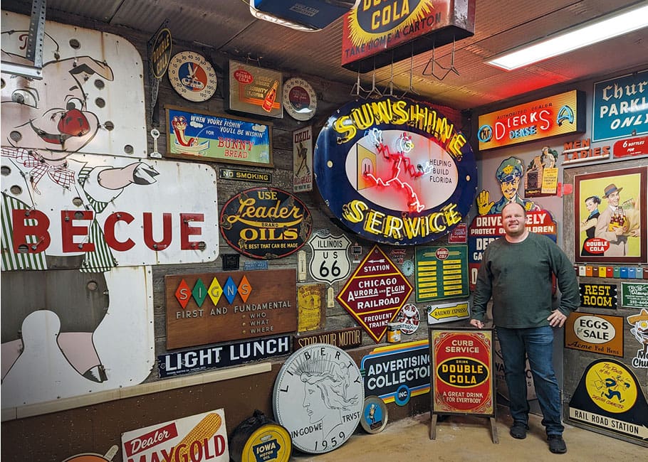Man standing in front of his collection of signs