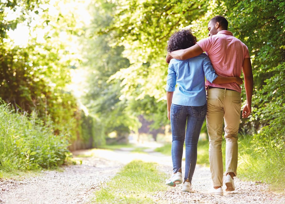 man and woman walking in woods