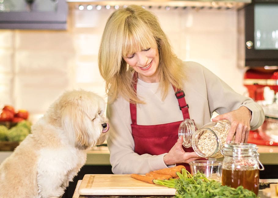 woman cooking with dog at counter