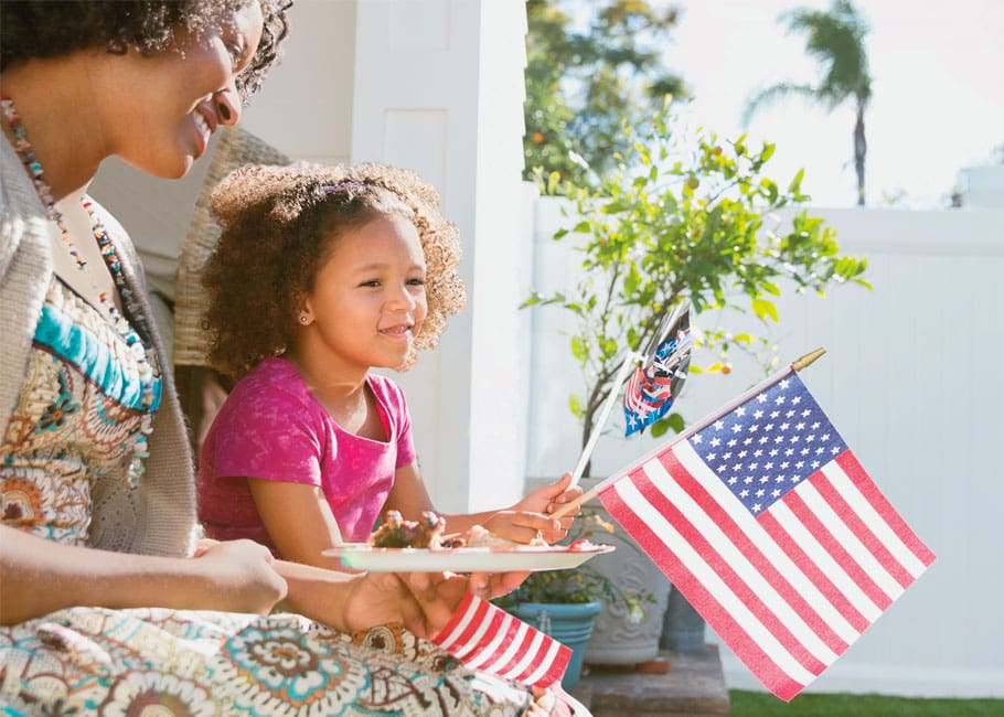 mother & daughter holding a USA flag