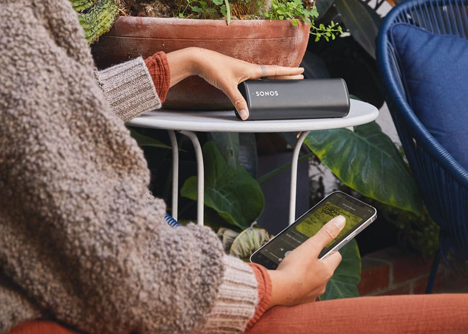 woman outdoors listening to Sonos portable speaker