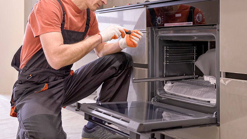 A man installing an oven in a kitchen