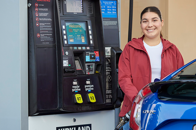 Image of a woman pumping gas into her car