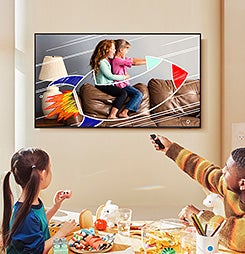Samsung QLED 4K TV displaying kids in a rocket. A family interacts in front.