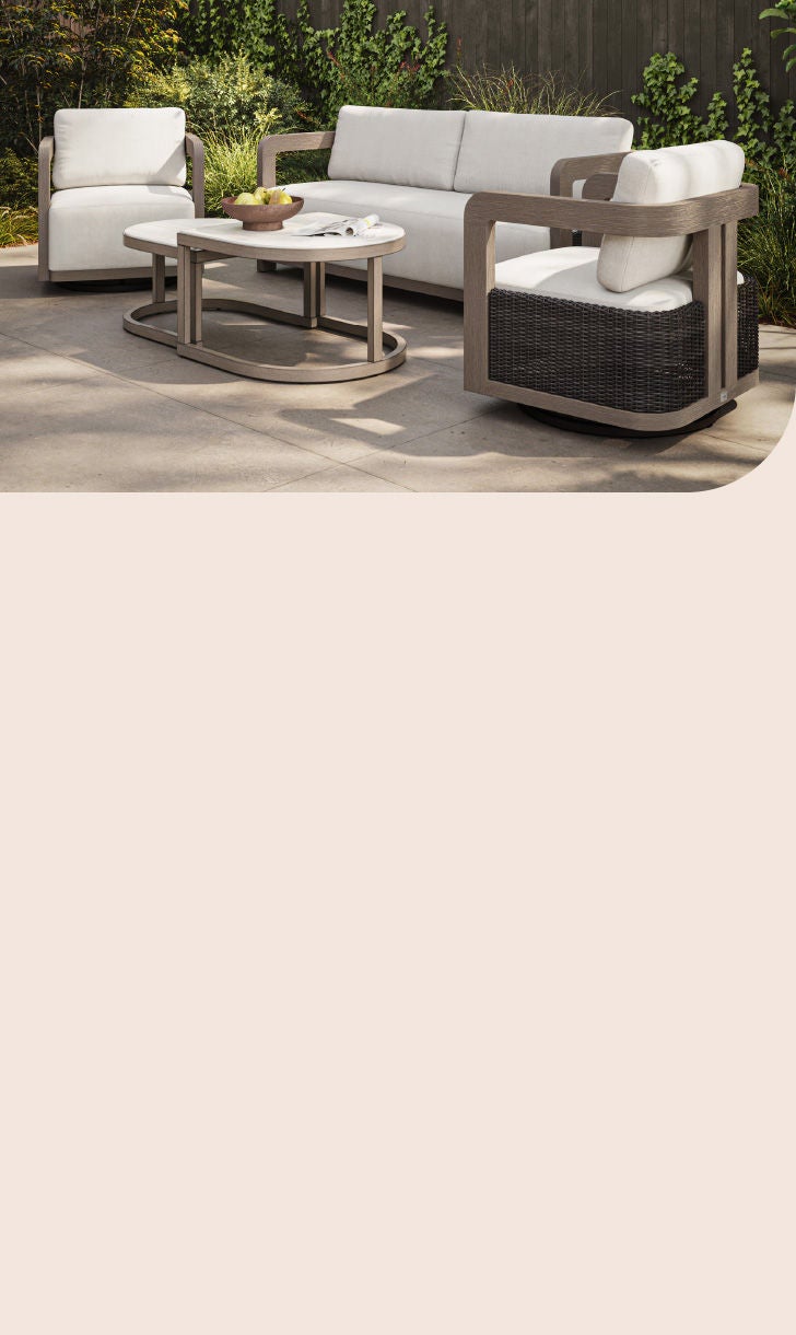 Modern Agio patio set with a cream sofa, two swivel chairs, and side tables on a stone patio.