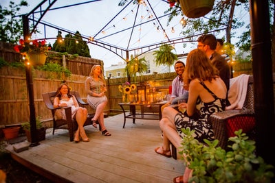 Several people sitting under a pergola in the summer