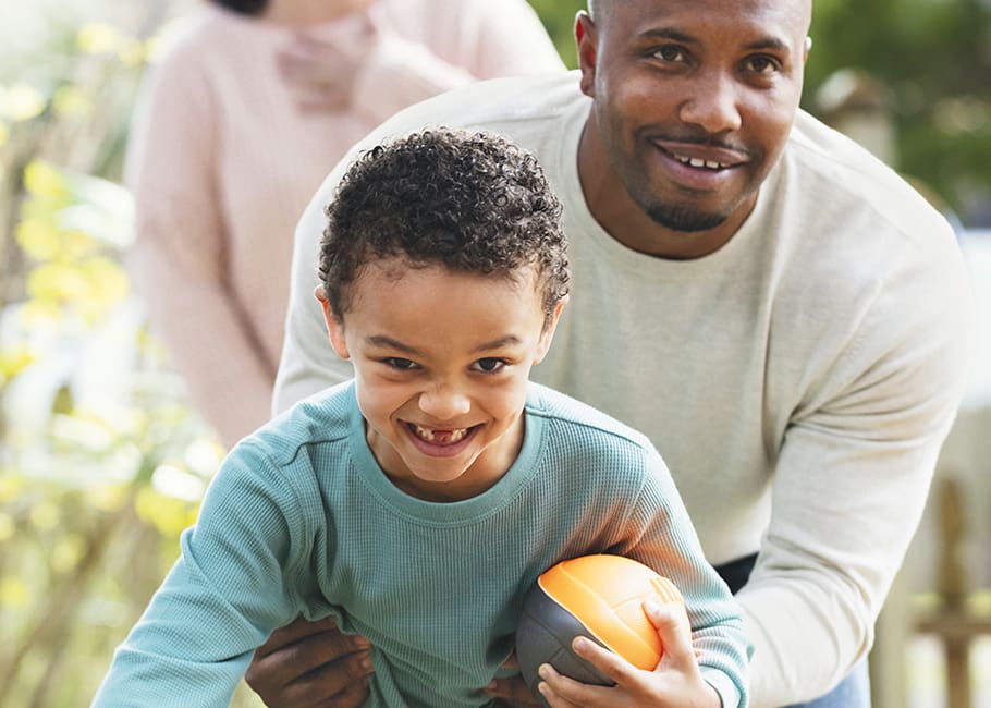 man and child playing football