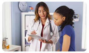 a doctor showing something on a tablet to a patient