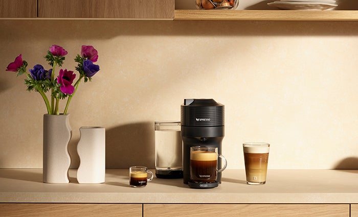 A black Nespresso Vertuo Pop+ machine on a kitchen counter.