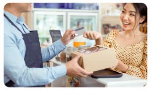 a man handing a credit card to a woman at a cafe