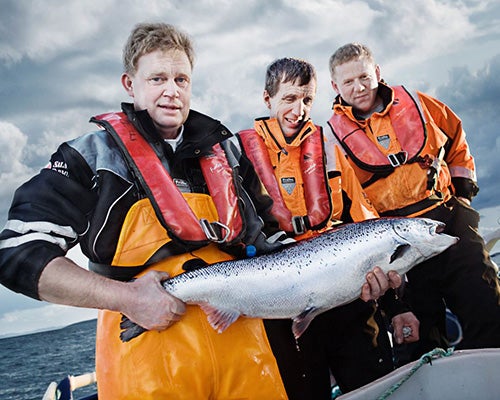 A group of fishermen holding a large fist on a boat